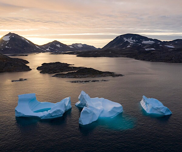 Melting icebergs float off the melted coast of Greenland this summer
