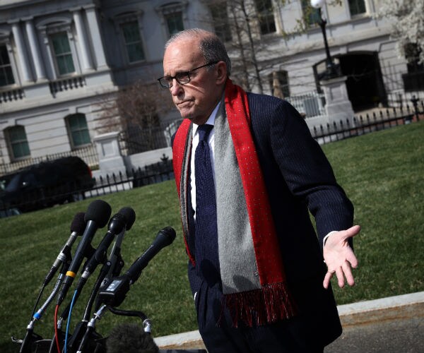 larry kudlow is shown outside the white house doing an interview