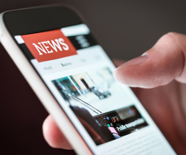 man reading online news on website with cellphone