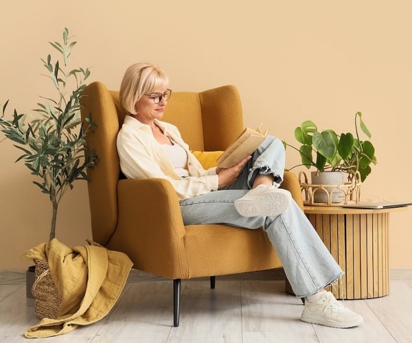 woman sitting in chair reading a book
