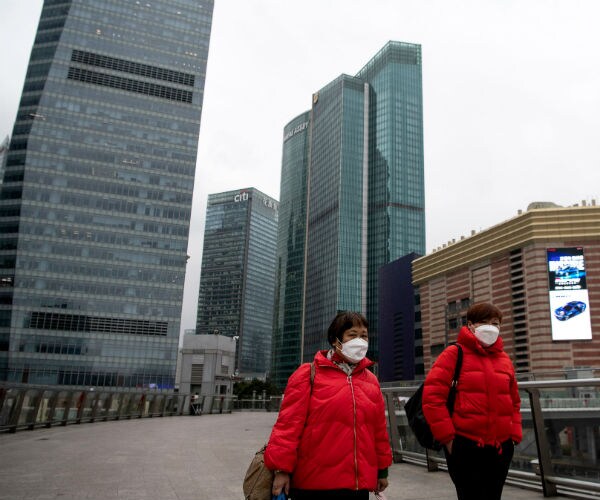 People wearing protective mask walk in the usually busy Lujiazui financial district in Pudong, Shanghai on Feb. 7, 2020