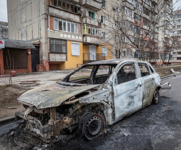 A car damaged by Grad missile parked in a street 