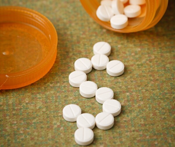 pills coming out of bottle in shape of dollar sign