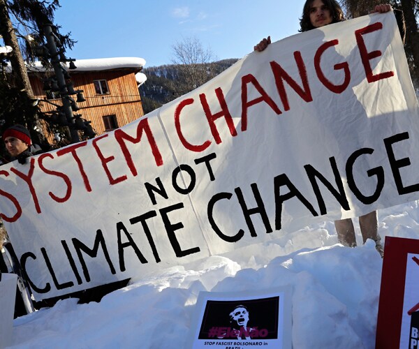 protesters hold a sign at the 2019 world economic forum in davos, switzerland