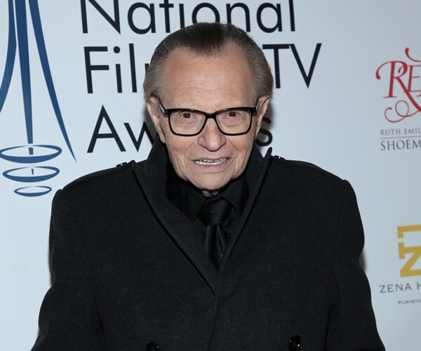 larry king poses for a photograph