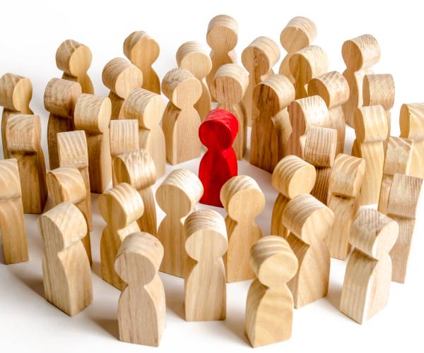 group of wooden people surround a figure to accuse him