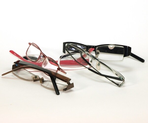 several pairs of reading glasses on white background