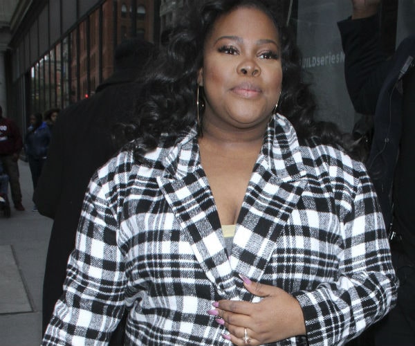 amber riley is shown in a black and white plaid coat