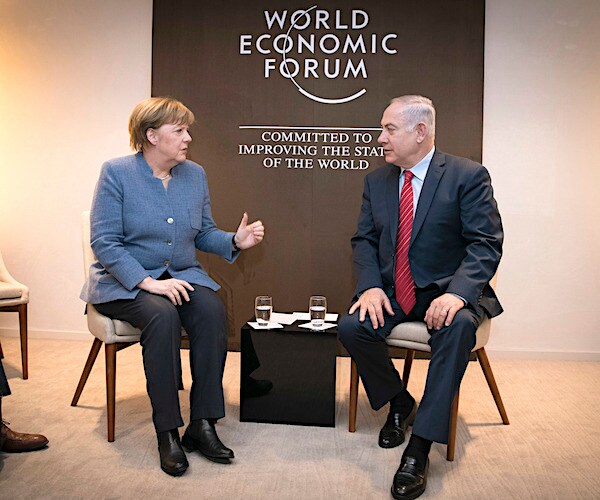 germany chancellor angela merkel sits down with israel's benjamin netanyahu at the world economic forum