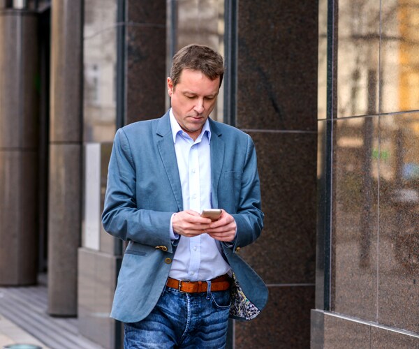 A man using his phone while walking
