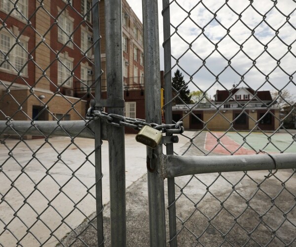 closed gate with a lock on it outside a courtyard of a school