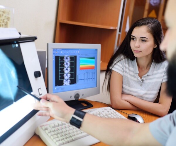 doctor reviewing mammography results with young woman