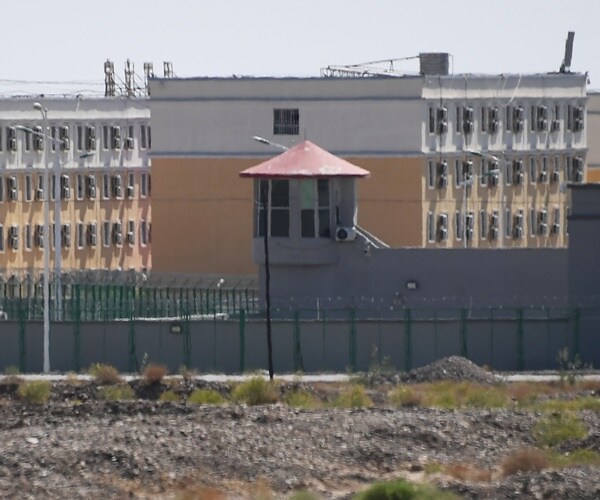 a barracks sits behind a fence with a guard house