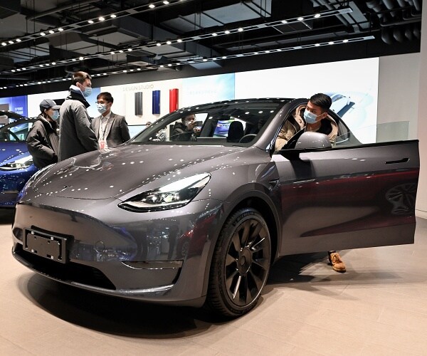 people look at tesla in showroom