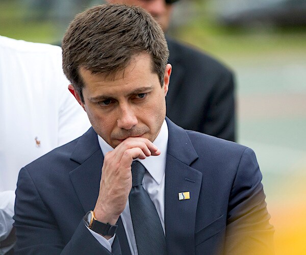 pete buttigieg rests his chin in his right hand while thinking