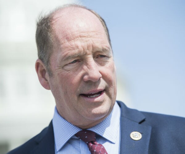 rep. ted yoho is shown speaking with reporters on the house steps