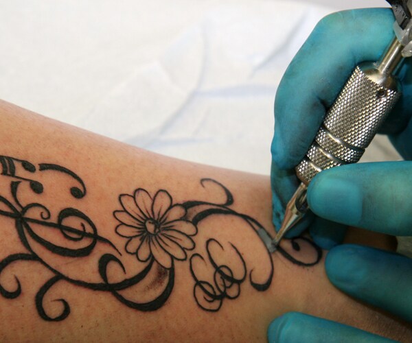 a tattoo artist adding a tattoo to someone