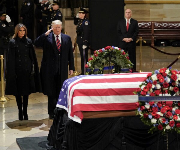 president trump salutes president bush's flag-draped casket as melania trump looks on