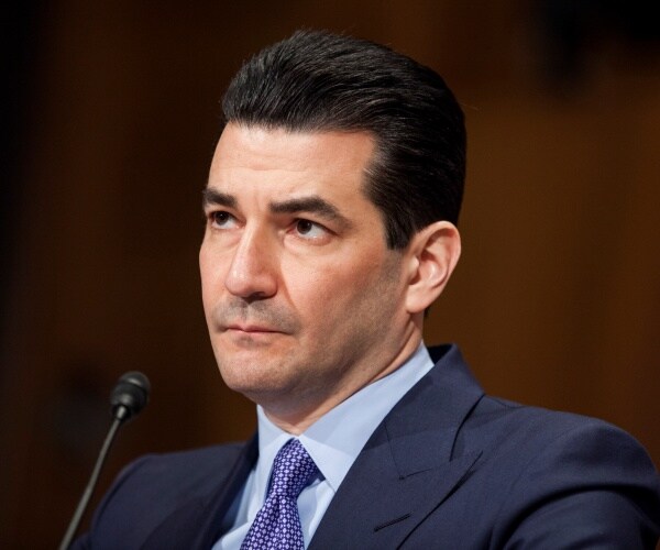 scott gottlieb sits behind table