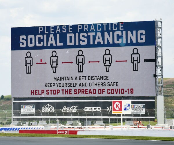 social distancing signage is displayed on the track for a nascar race in north carolina