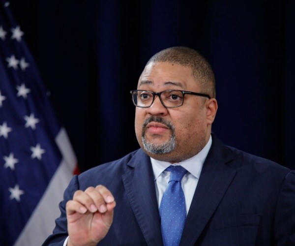 manhattan district attorney alvin bragg gestures with american flag