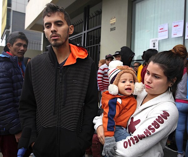 Venezuelan migrant couple Johan Alvarez and Daniela Tovar, with their son Matias, speak during an interview