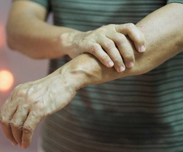 man holding wrist in pain from Guillain-Barre syndrome