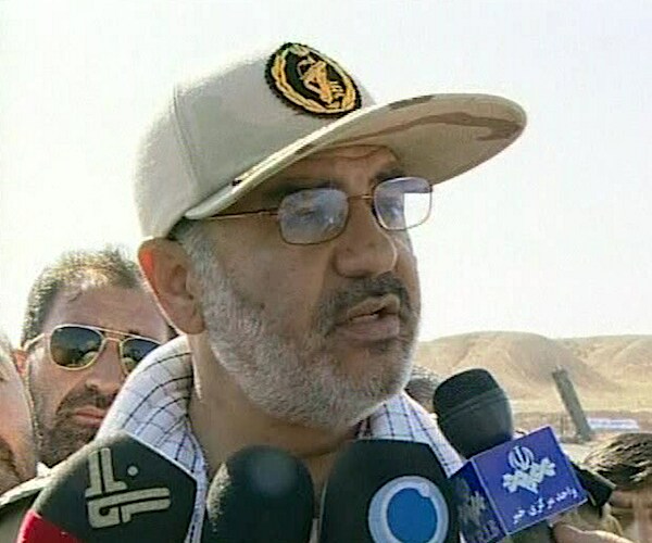 a man speaks to reporters in a middle eastern desert