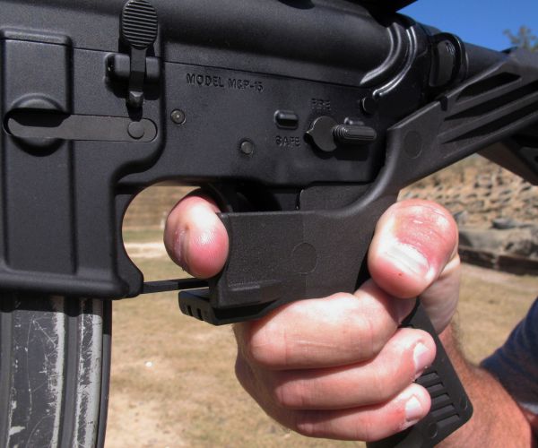 a shooting instructor demonstrates the grip on an ar-15 rifle fitted with a bump stock at a gun club