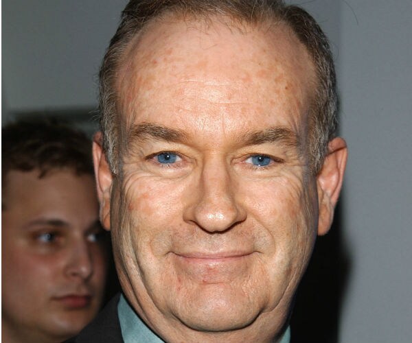 bill o'reilly stands and smiles while photographed by the media