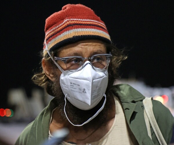 Danny Fenster wearing a masks, speaks to the press.