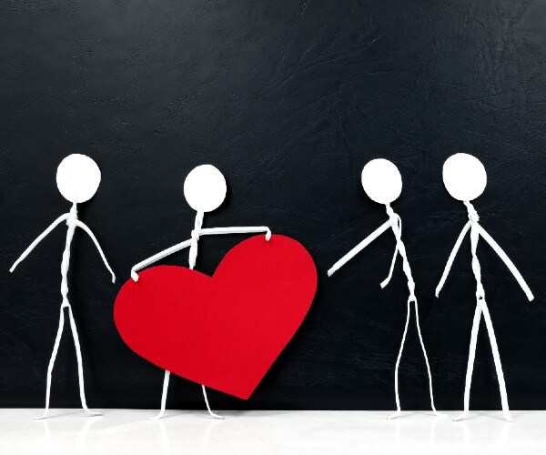 four stickmen with one givine a large heart to another