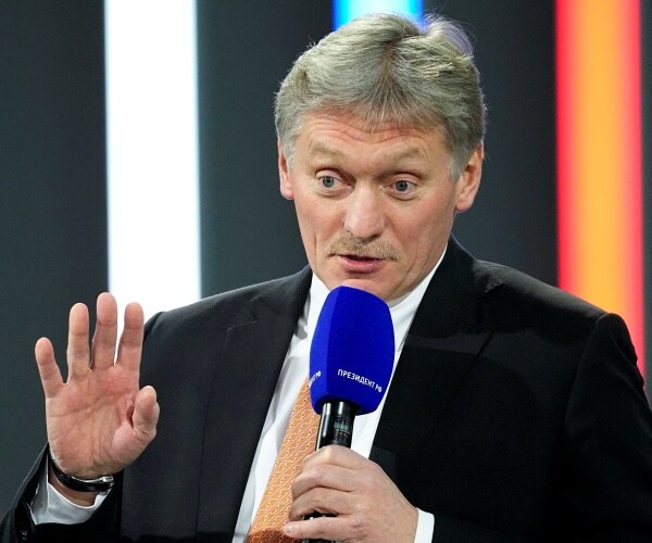 dmitry peskov speaks into a microphone