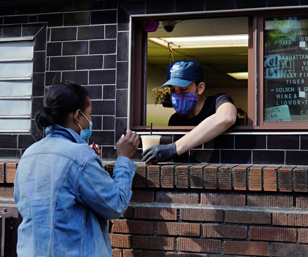 a woman picks up a drink to go at a new york city restaurant