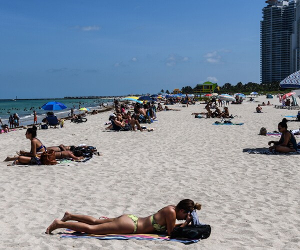 people relax in the sun at miami beach