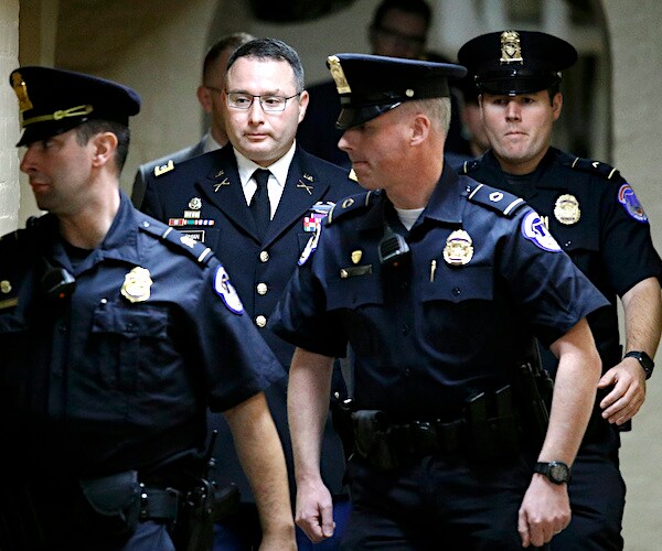 Army Lt. Col. Alexander Vindman is escorted by police officers after a closed door meeting Tuesday on Capitol Hill