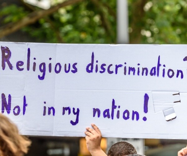 white political protest banner with blue lettering is being held 