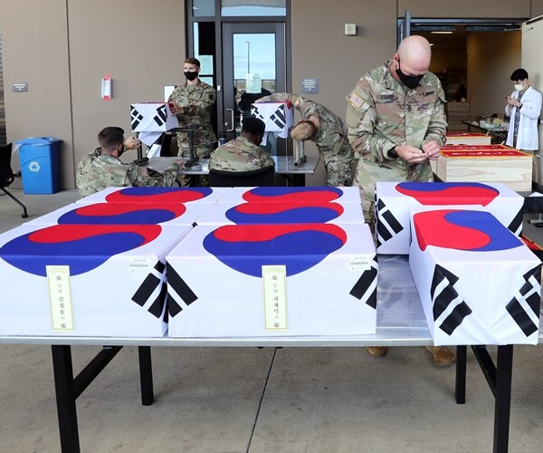 soldiers are wrapping coffins with south korean soldier's remains
