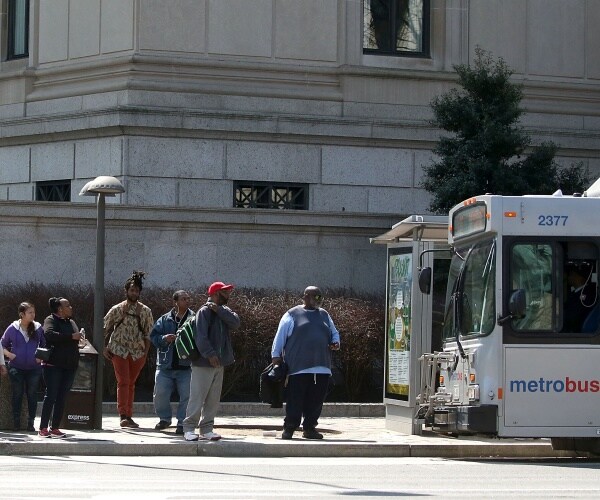 People stand at a bus stop