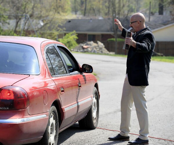 pastor chuck salvo prays with congregants after the drive-in service