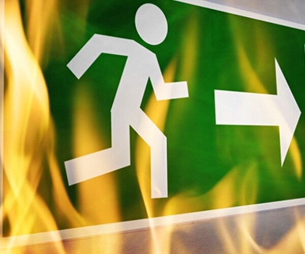 close-up of emergency fire exit board burning in the fire flame 

