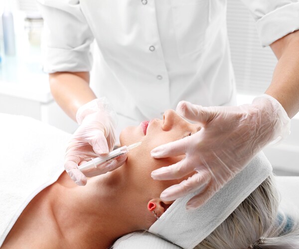a woman receiving a botox injection in her face
