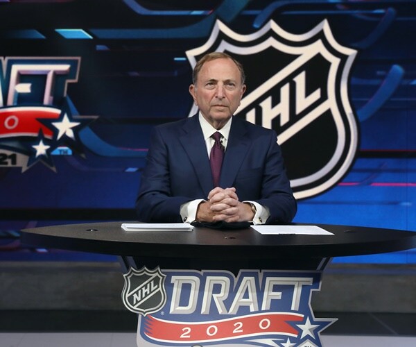 gary bettman speaks to the camera with signeage about the nhl draft