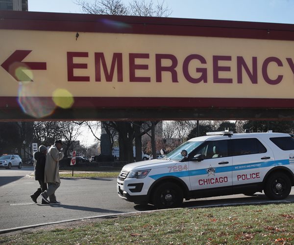 chicago police vehicle framed by emergency room sign outside hospital where fatal shooting occurred