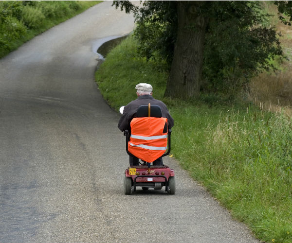 elderly man riding mobile scooter netherlands