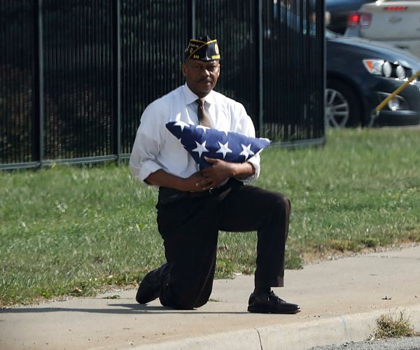 Veteran Holds Flag, Kneels as Trump Motorcade Passes in Viral Photo