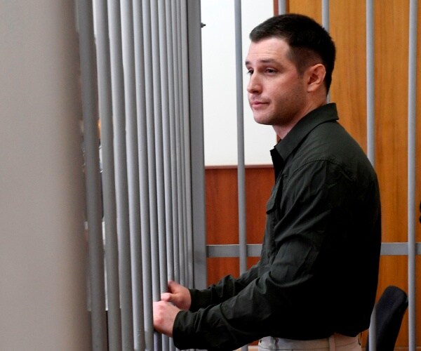 Trevor Reed stands in a holding cell