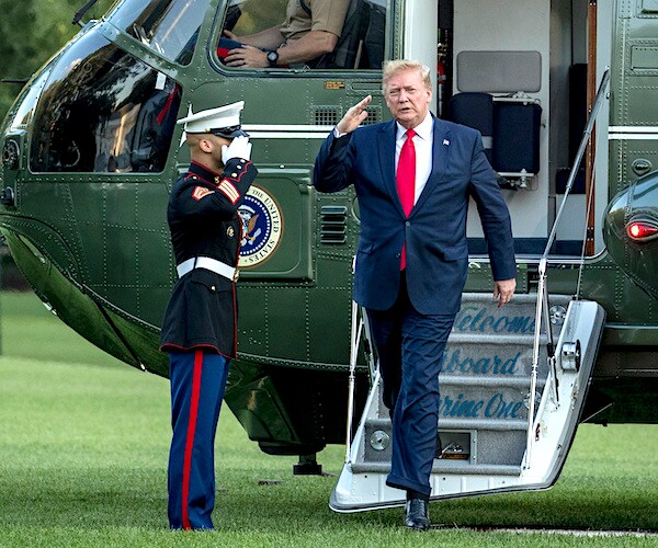 president donald trump salutes a serviceman upon exiting marine one