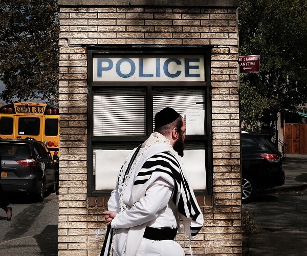 man walks past police sign 