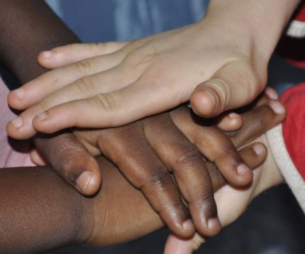 hands of girls of different colors stacked on each other